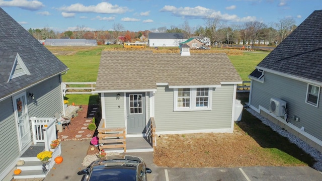 rear view of property featuring a shingled roof