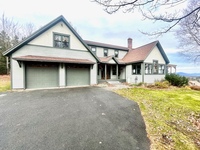 view of front of property featuring a garage and a front lawn