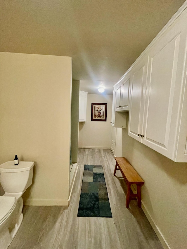 bathroom with a shower, wood-type flooring, and toilet