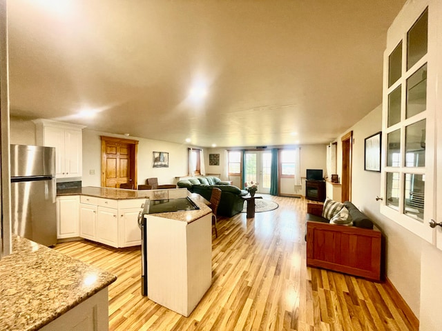 kitchen featuring white cabinets, stainless steel fridge, french doors, and light hardwood / wood-style flooring