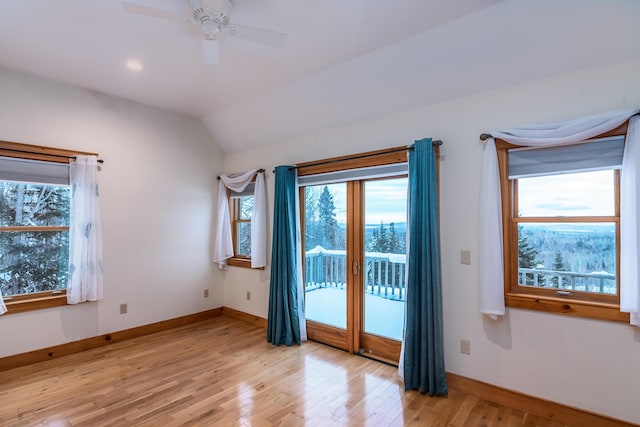 empty room with ceiling fan, light hardwood / wood-style floors, and lofted ceiling