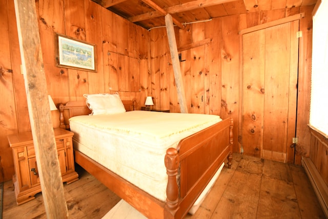 bedroom with wood walls and a baseboard radiator