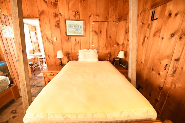 bedroom featuring wood-type flooring and wooden walls