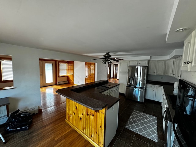 kitchen with dark hardwood / wood-style floors, ceiling fan, baseboard heating, a kitchen island, and stainless steel fridge with ice dispenser