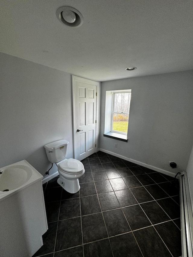 bathroom with tile patterned floors, vanity, toilet, and baseboard heating