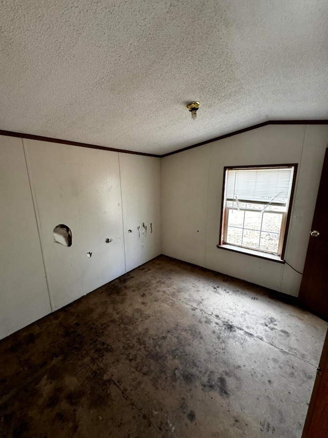 unfurnished room featuring a textured ceiling and vaulted ceiling