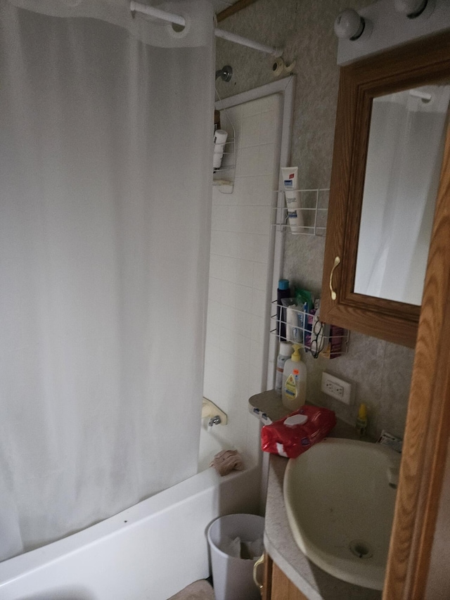 bathroom with shower / tub combo with curtain and sink