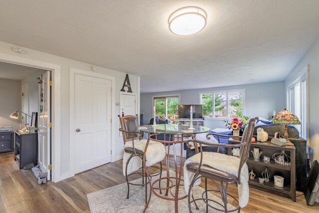 dining space featuring a textured ceiling and light wood-type flooring