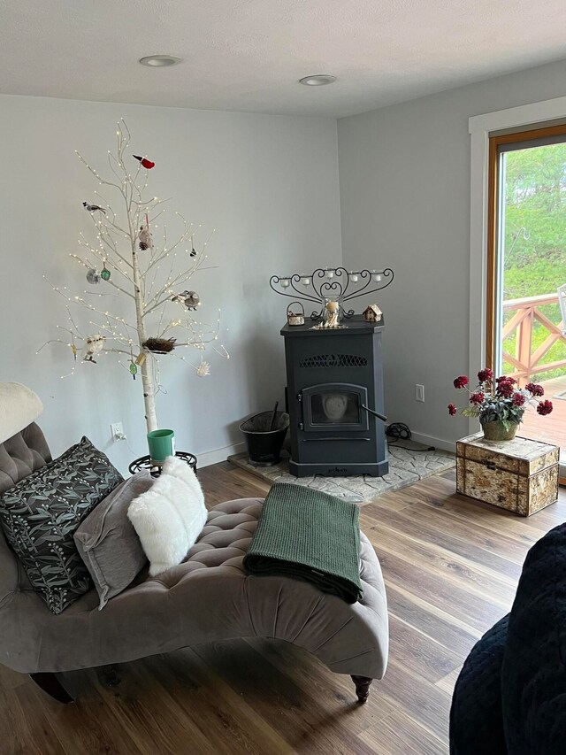 living room with hardwood / wood-style floors, a textured ceiling, and a wood stove