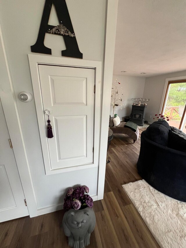 details with a wood stove and hardwood / wood-style floors