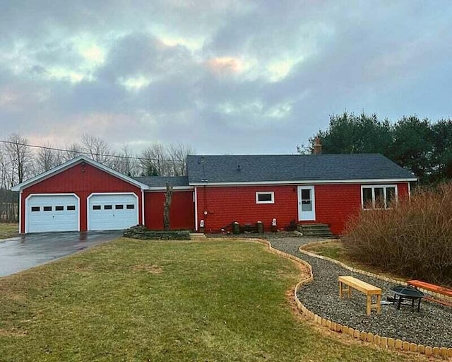 single story home with a fire pit, a garage, and a front yard