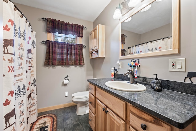 bathroom with toilet, vanity, and hardwood / wood-style flooring