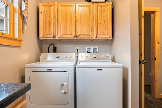 clothes washing area featuring dark wood-type flooring, cabinets, and washer and dryer