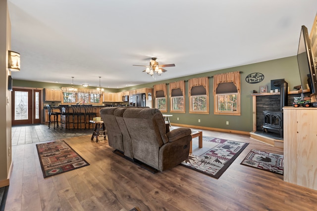 living room featuring hardwood / wood-style floors, a wood stove, and ceiling fan