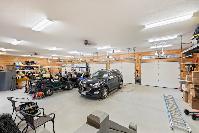 garage with a garage door opener and wooden walls