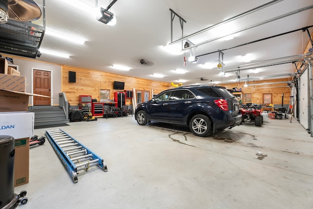 garage with a garage door opener and wooden walls