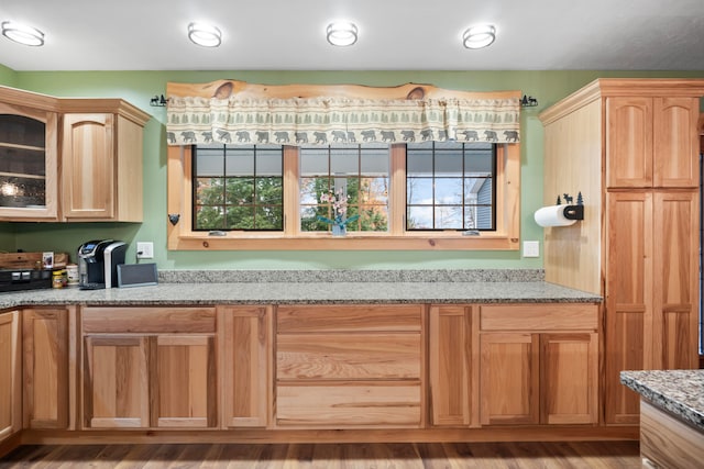 kitchen with light hardwood / wood-style floors, light stone countertops, and light brown cabinetry