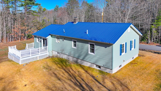 rear view of house featuring a yard and a deck