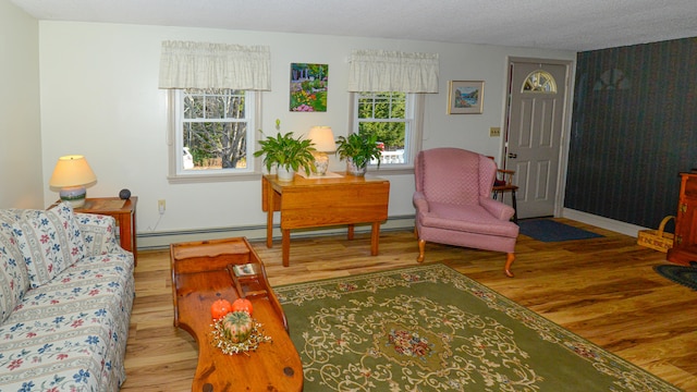 living room featuring hardwood / wood-style floors, a baseboard radiator, and a textured ceiling