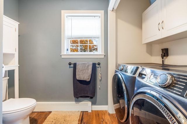 laundry area featuring independent washer and dryer, hardwood / wood-style flooring, and a baseboard radiator