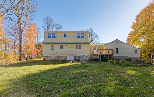 rear view of house featuring a lawn and a wooden deck