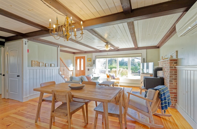 dining space featuring wooden ceiling, light hardwood / wood-style floors, beamed ceiling, and a wood stove