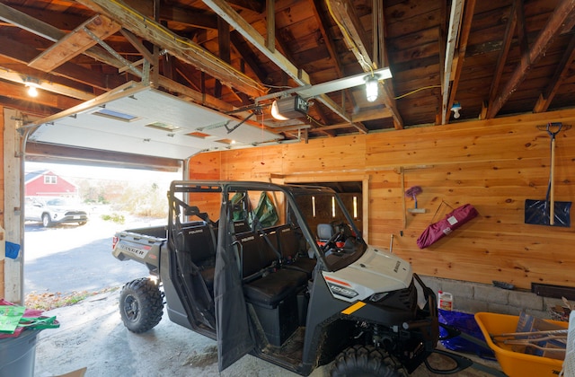 garage featuring a garage door opener and wooden walls