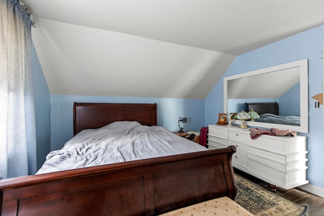 bedroom featuring dark hardwood / wood-style flooring and vaulted ceiling