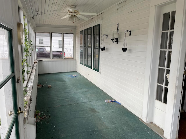 unfurnished sunroom featuring ceiling fan