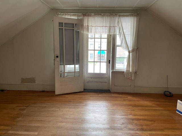 additional living space with light wood-type flooring and lofted ceiling