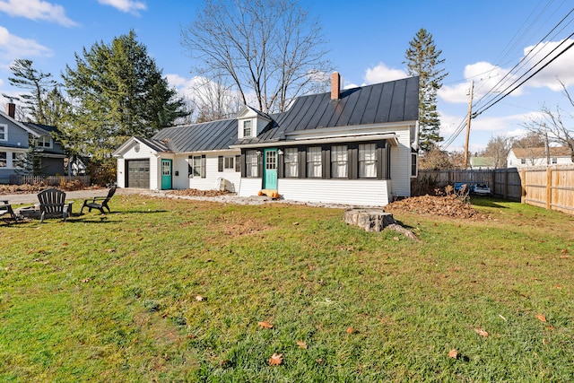 rear view of house with a lawn and an outdoor fire pit