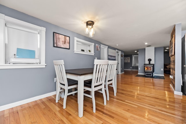 dining area featuring a wood stove and light wood-type flooring