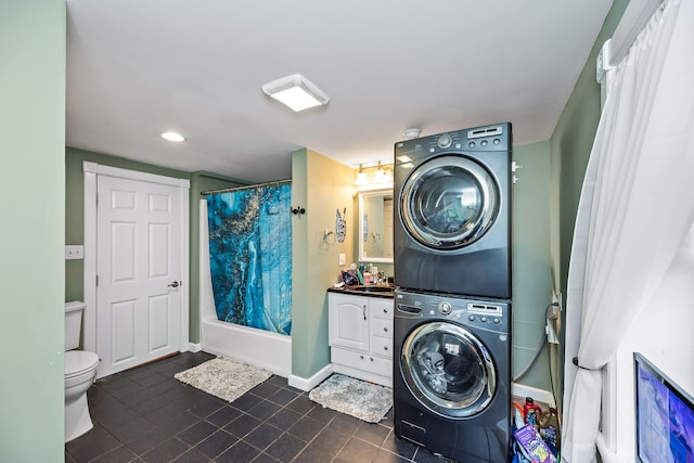 laundry area with stacked washer and dryer, sink, and dark tile patterned floors