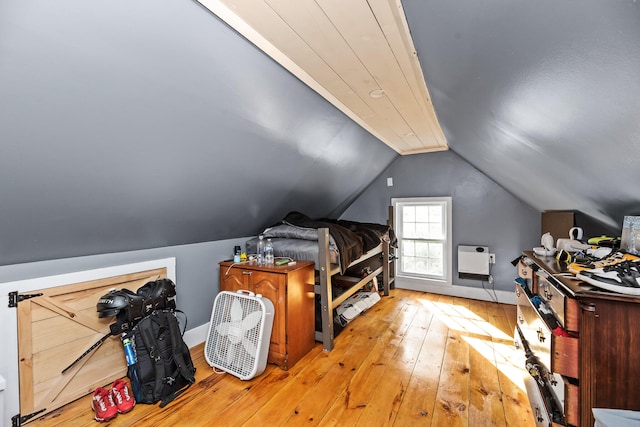 interior space featuring heating unit, light hardwood / wood-style flooring, and vaulted ceiling