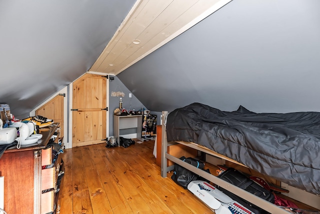 bedroom featuring vaulted ceiling and hardwood / wood-style flooring