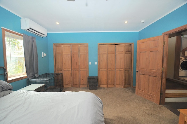 bedroom featuring multiple windows, carpet flooring, an AC wall unit, and two closets