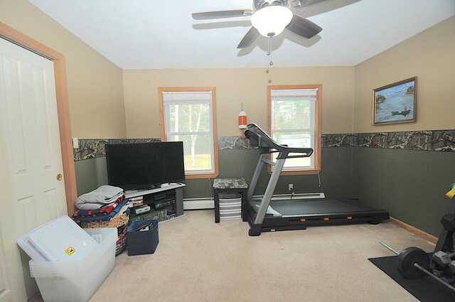 exercise room with carpet flooring, a baseboard heating unit, plenty of natural light, and ceiling fan