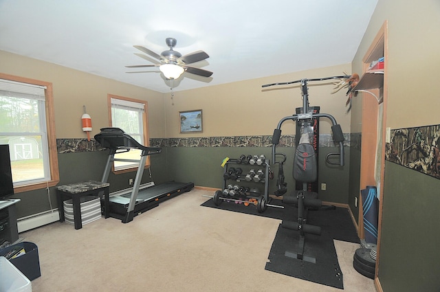 workout area featuring a baseboard heating unit, light colored carpet, and ceiling fan