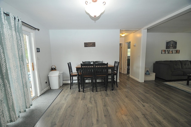 dining room with a baseboard heating unit and dark hardwood / wood-style flooring