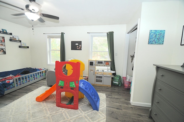 bedroom with dark hardwood / wood-style flooring and ceiling fan