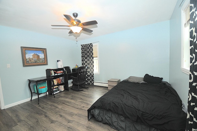 bedroom featuring baseboard heating, dark wood-type flooring, and ceiling fan