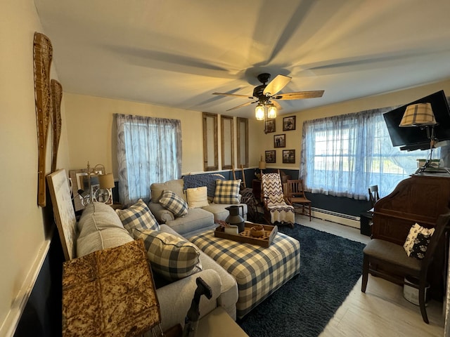 living room with light wood-type flooring, ceiling fan, and a baseboard heating unit