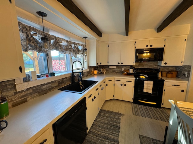 kitchen with decorative backsplash, black appliances, sink, pendant lighting, and white cabinetry