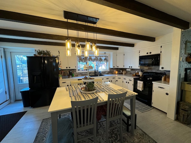 dining area with plenty of natural light, beamed ceiling, and sink