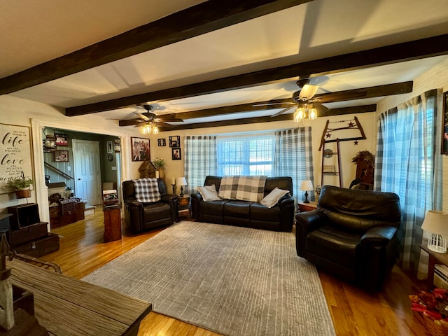 living room featuring ceiling fan, hardwood / wood-style flooring, and beamed ceiling