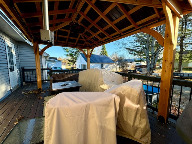 wooden terrace featuring ceiling fan, a grill, and a gazebo