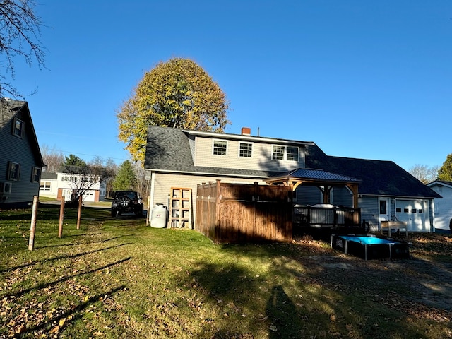 rear view of house with a yard and a gazebo