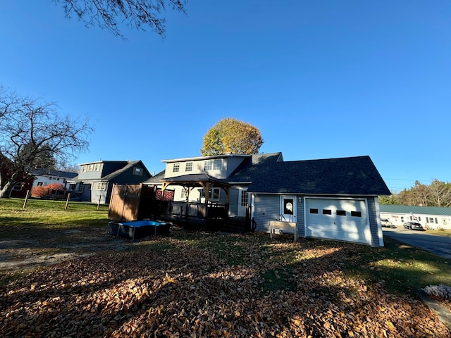 view of front facade with a garage, a front lawn, and a deck