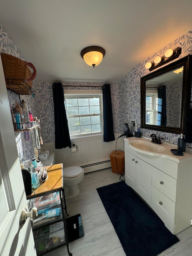 bathroom featuring baseboard heating, vanity, and toilet