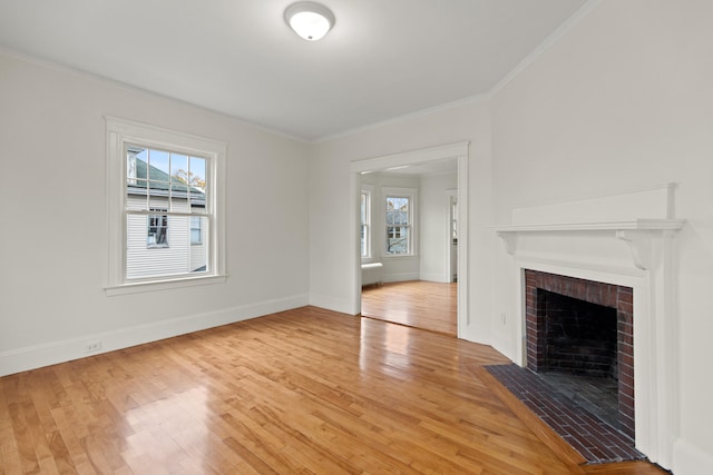 unfurnished living room featuring hardwood / wood-style floors, a fireplace, and crown molding